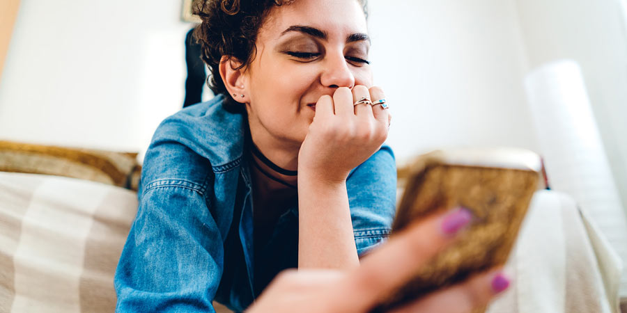 Lesbian woman reading her online dating messages on her mobile 